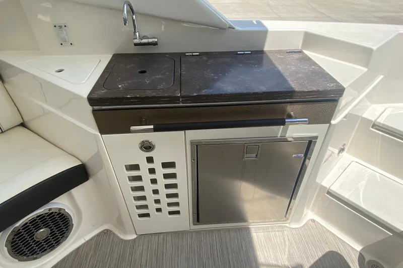 Slide: The Image of 2018 Sea Ray SLX 350 boat kitchenette with sink, countertop, and mini fridge. - 15