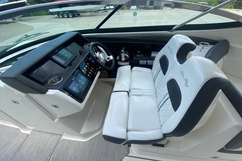 Slide: The Image of 2018 Sea Ray SLX 350 cockpit with dual touchscreen displays and luxurious white seating. - 23