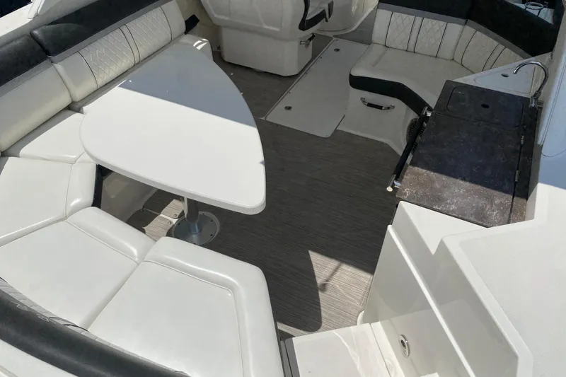 Slide: The Image of 2018 Sea Ray SLX 350 boat interior with white seating and a triangular table. - 13