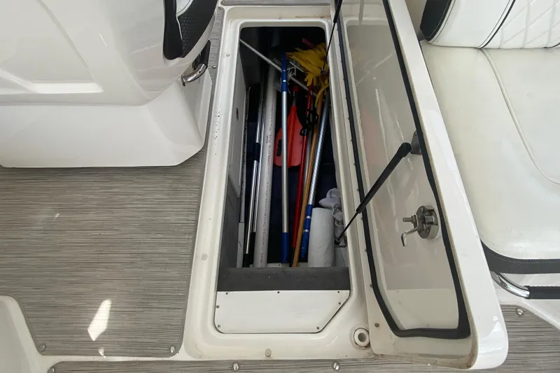 Slide: The Image of Open storage compartment on 2018 Sea Ray SLX 350 boat, containing various boating equipment. - 43