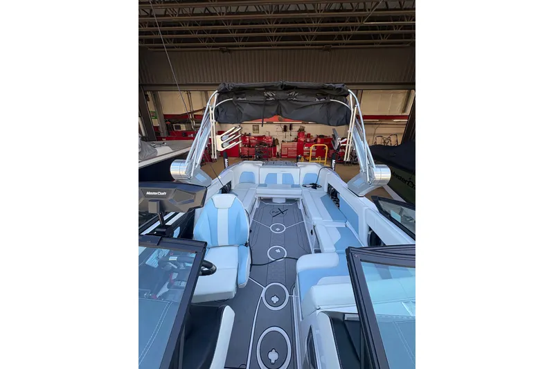 Slide: The Image of 2022 MasterCraft X24 boat interior with sleek seating and modern design in a garage setting. - 4