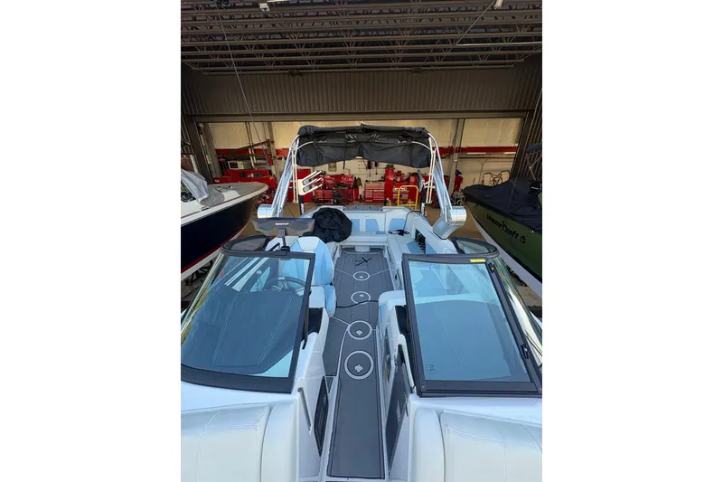 Slide: The Image of 2022 MasterCraft X24 boat interior with sleek design and modern features in a garage setting. - 3