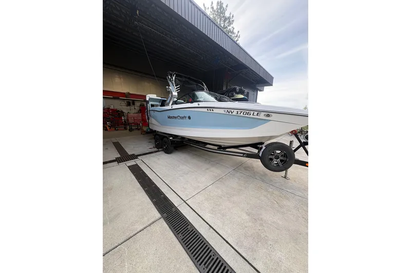 The Image of 2022 MasterCraft X24 boat on trailer in garage setting. - 0