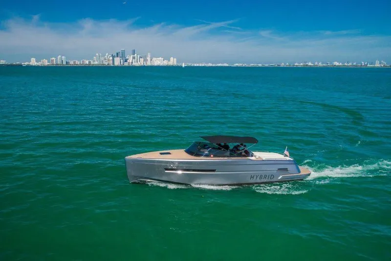 Slide: The Image of 2018 Canard Yachts eMotion HYBRID cruising on turquoise waters with city skyline backdrop. - 6
