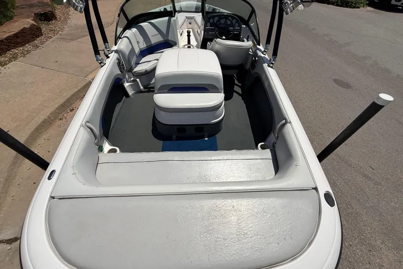 Slide: The Image of 2001 Moomba Outback boat interior with white seating and steering wheel, parked on pavement. - 7