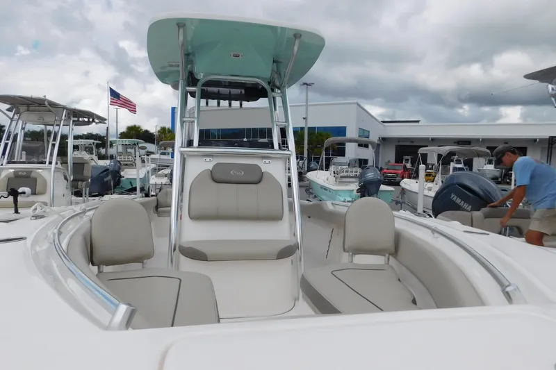 Slide: The Image of 2024 Key West 239 FS boat with seating, displayed at a dealership under cloudy skies. - 11