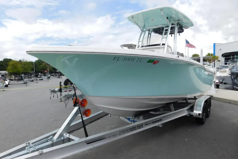 Slide: The Image of 2024 Key West 239 FS boat on trailer, displayed outdoors with American flag in background. - 1