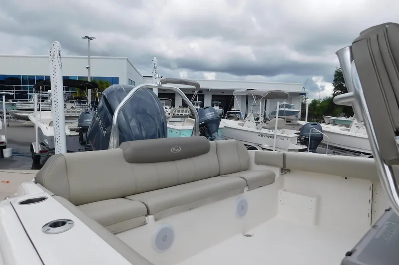 Slide: The Image of 2024 Key West 239 FS boat with seating, displayed at a dealership under cloudy skies. - 6
