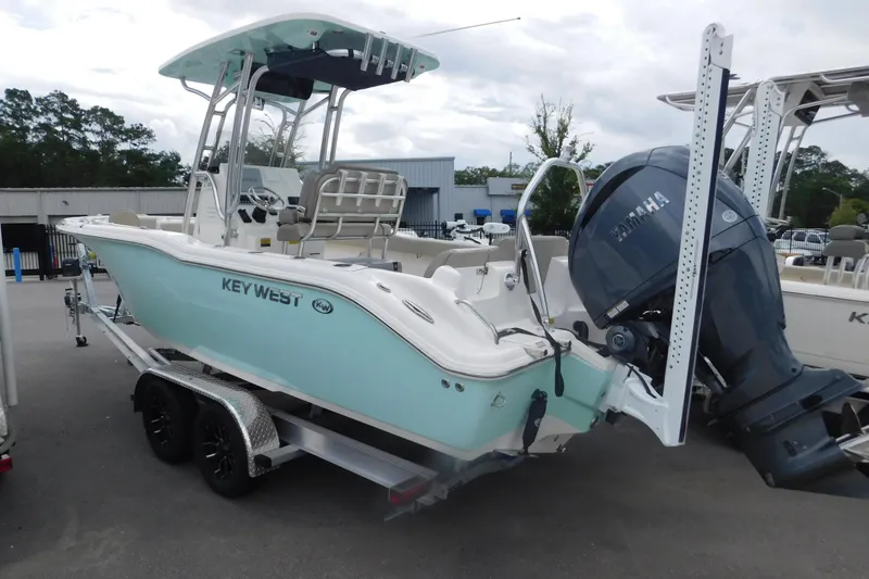 Slide: The Image of 2024 Key West 239 FS boat with Yamaha engine on trailer, parked outdoors. - 2