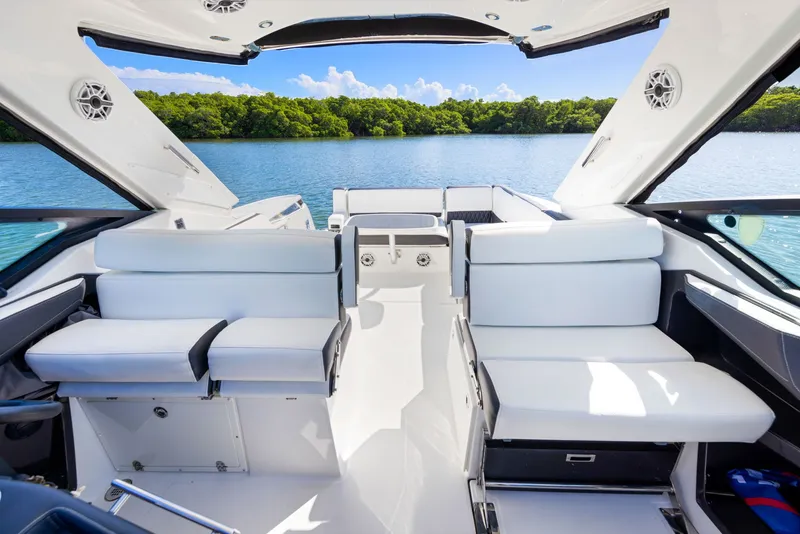 Slide: The Image of The image shows the cockpit of a 2017 Monterey 378SE Super Express. It features white seating and is on calm water with green trees in the background. - 15
