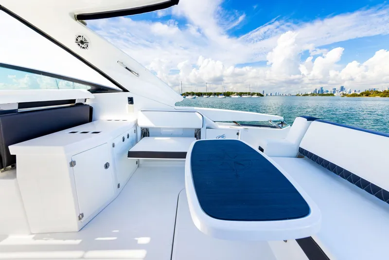 Slide: The Image of The image shows the deck of a 2017 Monterey 378SE Super Express. It features a stylish seating area with a table, overlooking the water and skyline in the background. - 32