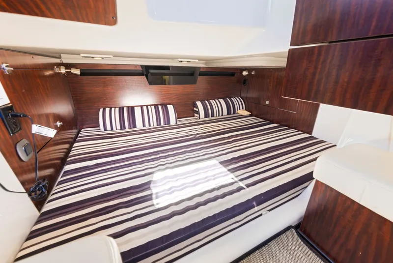 Slide: The Image of Interior of a 2017 Monterey 378SE Super Express with striped bedding and wooden walls. - 24