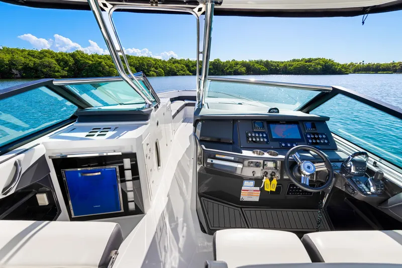 Slide: The Image of The cockpit of a 2017 Monterey 378SE Super Express with modern helm and blue refrigerator. - 13