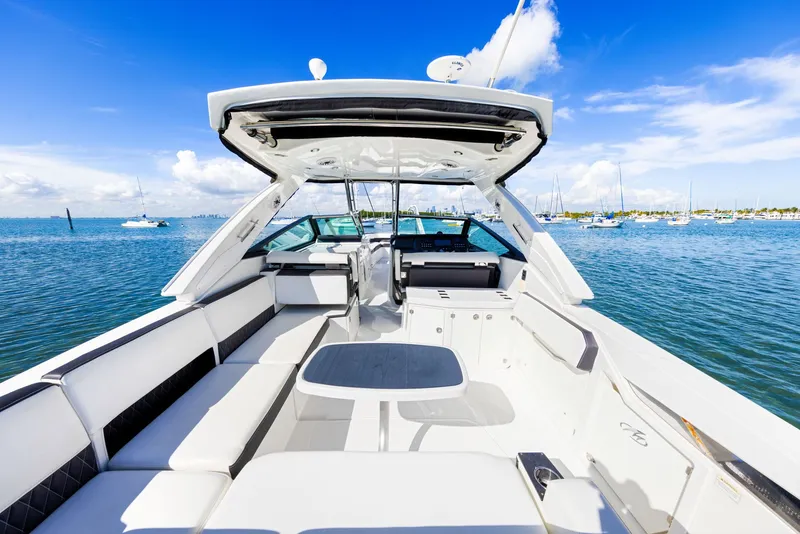 Slide: The Image of The image shows a luxury boat with white seating and a table, set on calm water. - 16