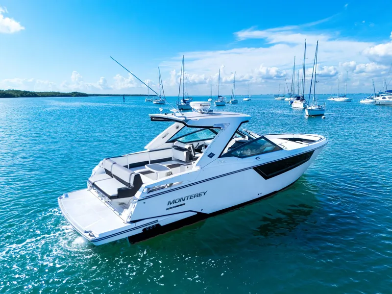 Slide: The Image of A white 2017 Monterey 378SE Super Express boat on calm water with other boats in the background. - 4