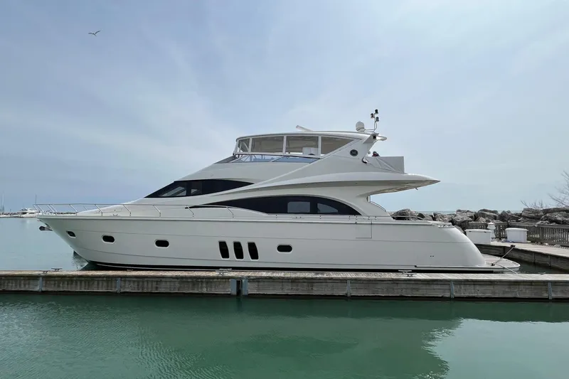 The Image of 2008 Marquis 65 Skylounge yacht docked in a serene marina setting. - 0