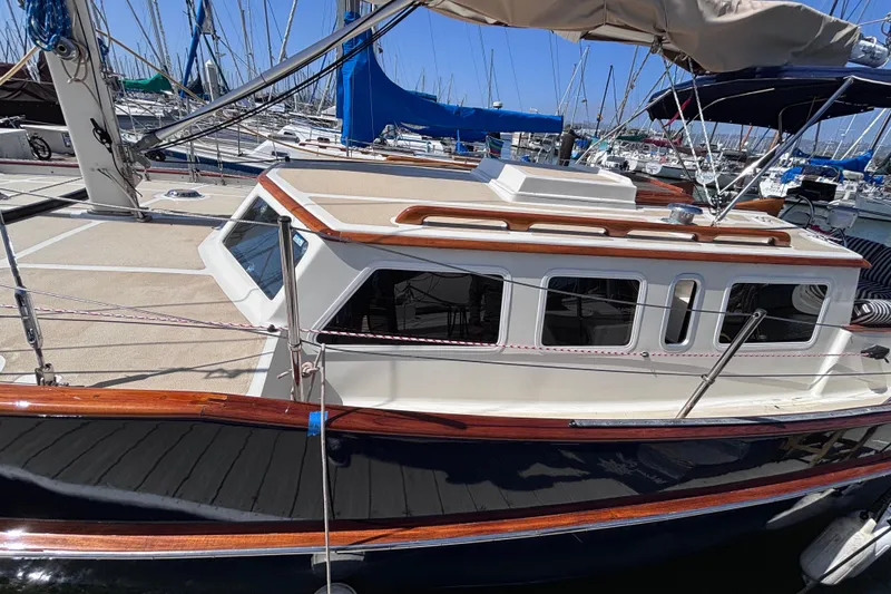 Slide: The Image of 1978 Swift 33 sailboat docked at a marina, showcasing classic design and wooden accents. - 10