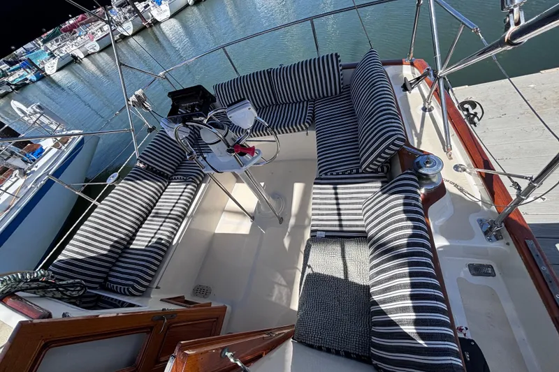 Slide: The Image of Cockpit of a 1978 Swift 33 sailboat with striped cushions, docked at a marina. - 12