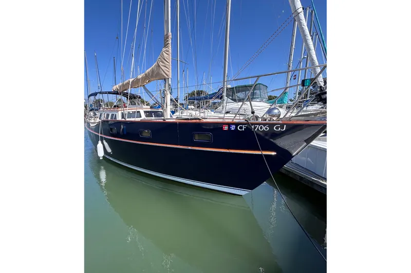 Slide: The Image of 1978 Swift 33 sailboat docked in marina, featuring sleek design and blue hull. - 3