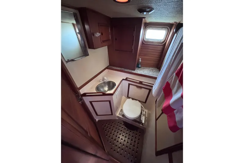 Slide: The Image of 1978 Swift 33 yacht bathroom with wooden cabinetry, sink, and porthole window. - 43