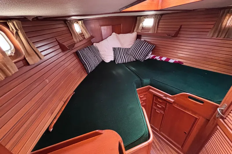 Slide: The Image of Cozy cabin interior of 1978 Swift 33 sailboat with green cushions and striped pillows. - 22