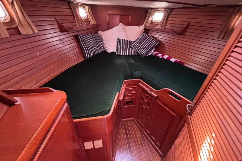Slide: The Image of Cozy cabin interior of 1978 Swift 33 sailboat with wooden paneling and green bedding. - 23