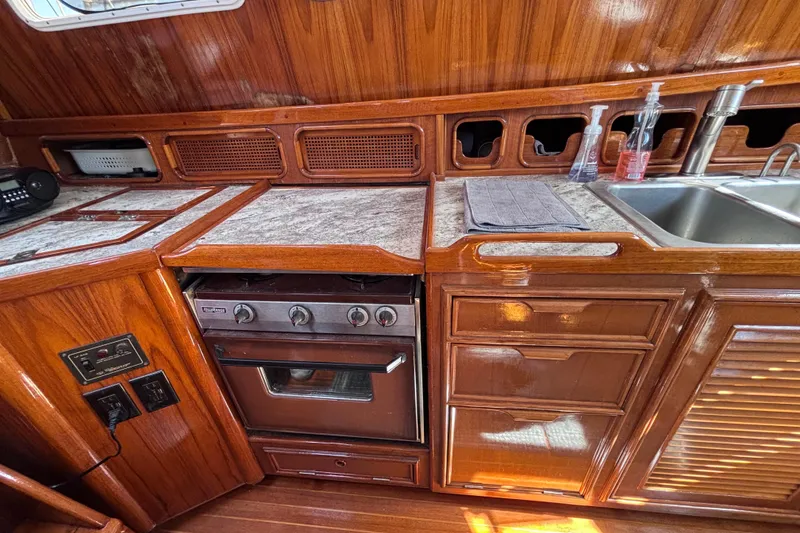 Slide: The Image of Vintage 1978 Swift 33 yacht kitchen with wooden cabinetry, stove, and sink. - 20