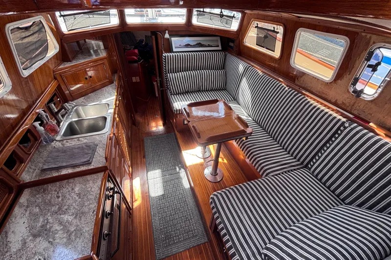 Slide: The Image of 1978 Swift 33 yacht interior with striped seating, wooden finishes, and compact kitchen area. - 16