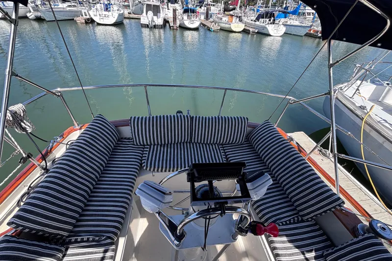 Slide: The Image of Cockpit of 1978 Swift 33 sailboat with striped cushions, docked in marina. - 11