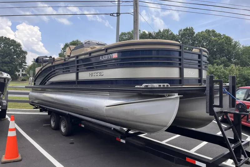 Slide: The Image of 2022 Harris Solstice 230 CWDH pontoon boat on trailer in parking lot. - 2