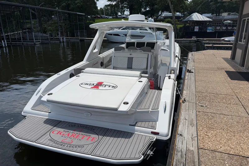 Slide: The Image of 2015 Cigarette 41' Nighthawk SD Edition docked, showcasing sleek design and spacious deck. - 2
