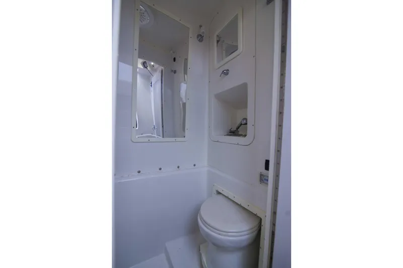 Slide: The Image of Compact bathroom in 2019 Midnight Express 43 Open boat, featuring toilet and mirror. - 16