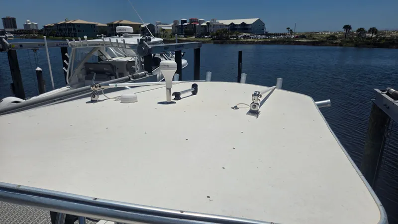 Slide: The Image of A boat docked with a view of calm water and buildings in the background. - 16