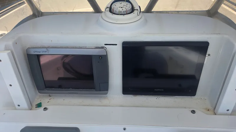Slide: The Image of Two Garmin screens and a compass on a boat's dashboard. - 9