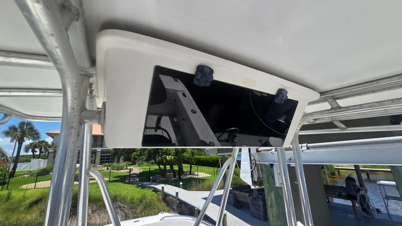 Slide: The Image of A boat with a white roof and a black panel underneath. It is situated in a marina. - 11