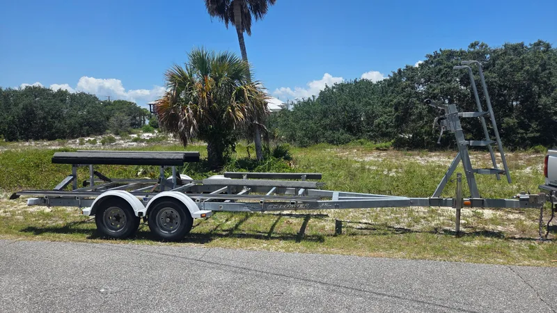 Slide: The Image of A boat trailer sits on a road, surrounded by palm trees and bushes. - 20