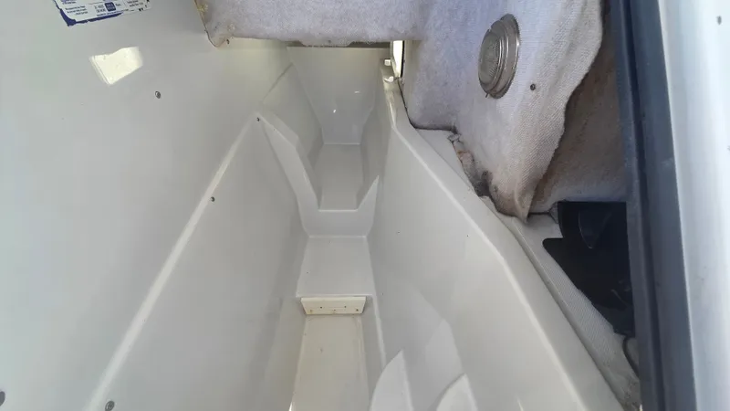 Slide: The Image of Interior view of a boat with white storage space and gray carpeting. - 13