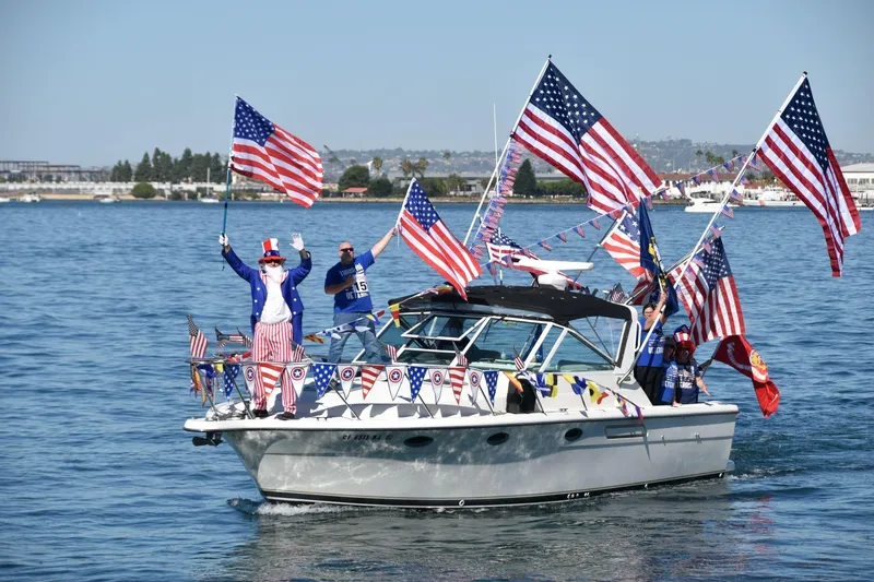 Slide: The Image of 1995 Tiara Yachts 3100 Open adorned with American flags, celebrating on the water. - 0
