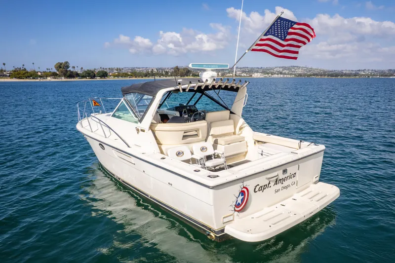 Slide: The Image of 1995 Tiara Yachts 3100 Open boat on water, American flag waving, sunny day. - 6