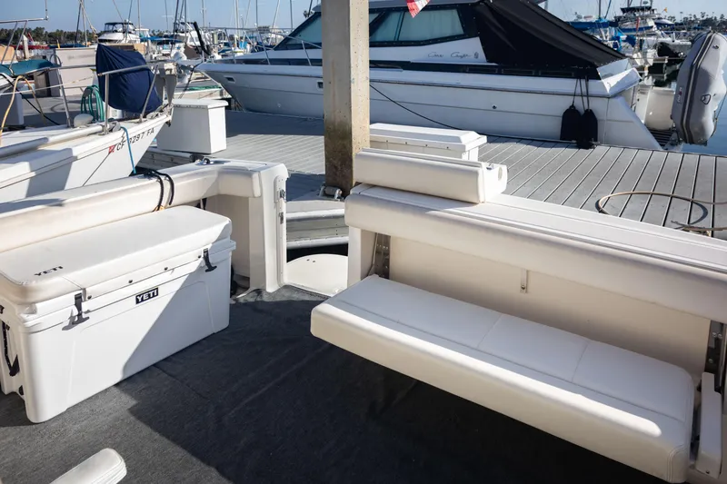 Slide: The Image of 1995 Tiara Yachts 3100 Open interior with seating and Yeti cooler at marina. - 20