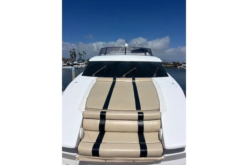 Slide: The Image of 1999 Horizon 70 Motor Yacht with beige and black deck cushions, docked under blue sky. - 4