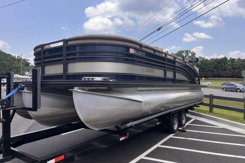 Slide: The Image of 2022 Harris Solstice 230 CWDH pontoon boat on trailer in parking lot. - 1