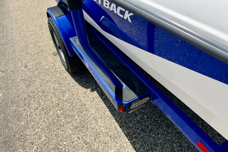 Slide: The Image of 2008 Moomba Outback V boat trailer, blue and white, on asphalt surface. - 74