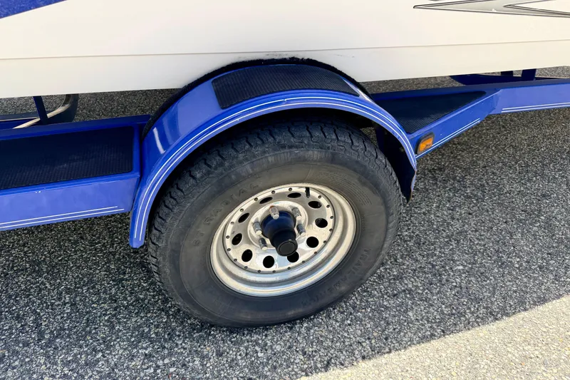 Slide: The Image of Blue trailer wheel of 2008 Moomba Outback V boat on asphalt surface. - 72