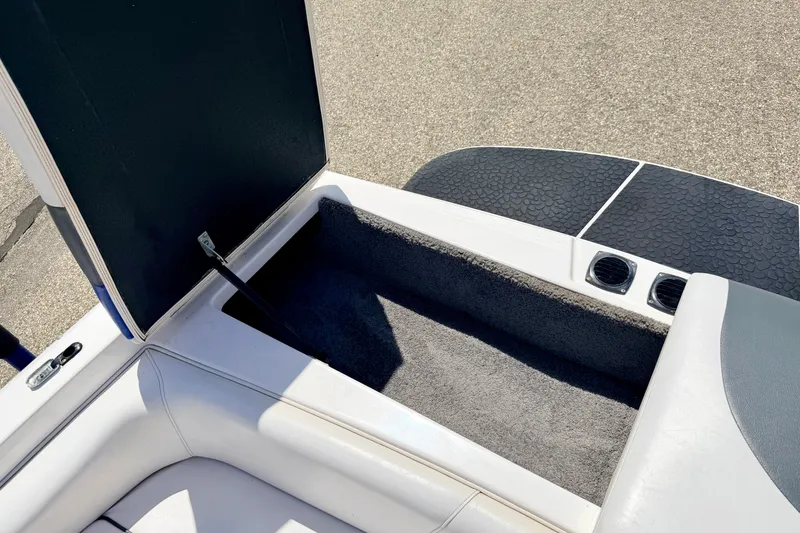 Slide: The Image of Open storage compartment in 2008 Moomba Outback V boat, featuring cushioned seating and carpeted interior. - 20
