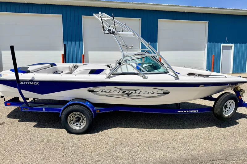 Slide: The Image of 2008 Moomba Outback V boat on trailer, parked outside blue building. - 5