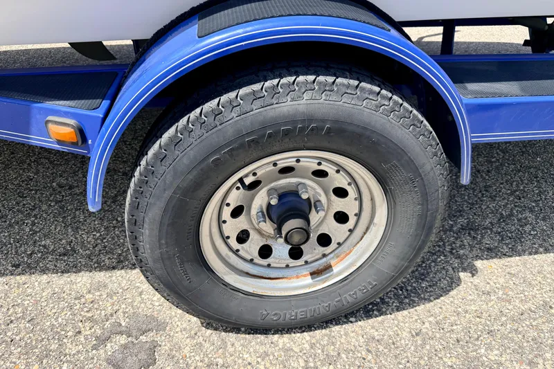 Slide: The Image of 2008 Moomba Outback V trailer wheel with blue fender on asphalt surface. - 69