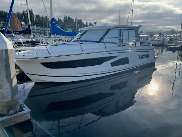 Slide: The Image of A 2021 Jeanneau NC 1095 is docked in a calm marina. - 34