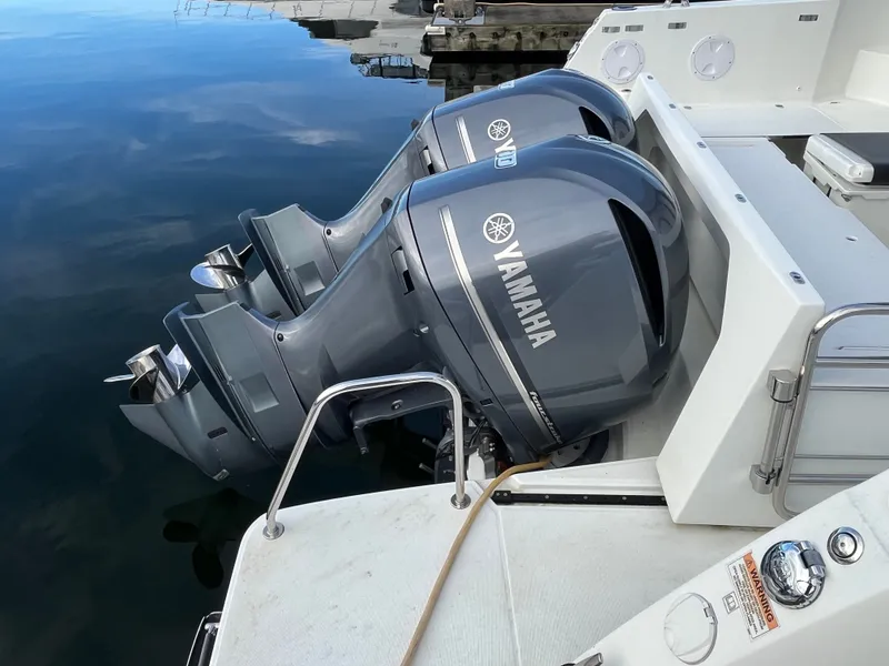Slide: The Image of Two Yamaha outboard engines on a Jeanneau NC 1095 boat, floating on calm water. - 35