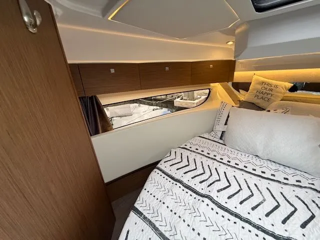 Slide: The Image of Interior of a 2021 Jeanneau NC 1095 with cozy bed and wood paneling. - 30